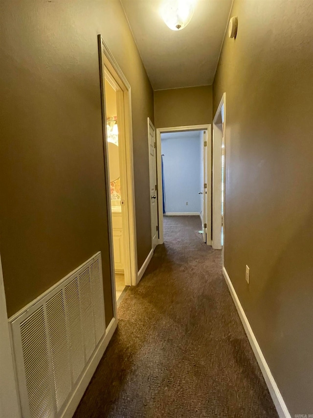 hallway featuring dark colored carpet