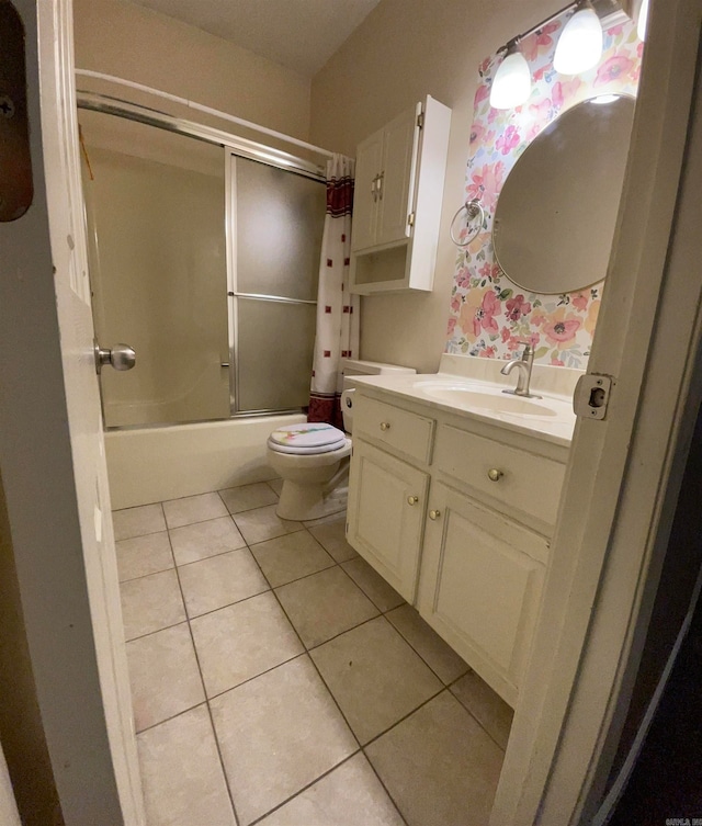 full bathroom featuring toilet, vanity, shower / bath combo with shower curtain, and tile patterned flooring