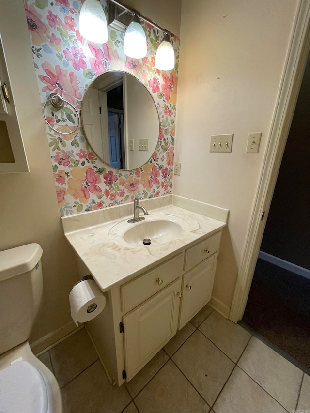 bathroom with toilet, vanity, and tile patterned floors