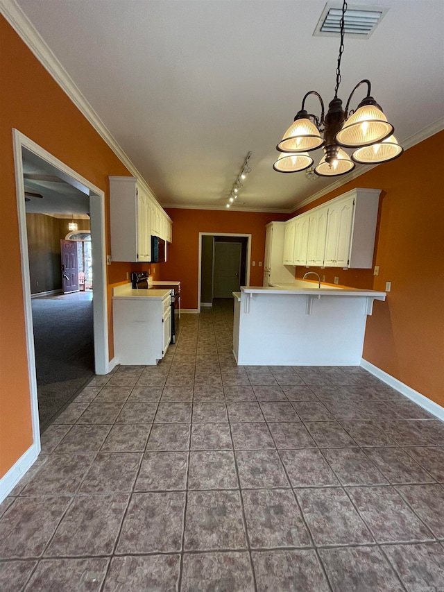 kitchen with crown molding, stove, a kitchen breakfast bar, white cabinets, and kitchen peninsula