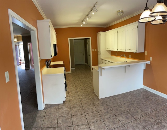 kitchen featuring white cabinets, kitchen peninsula, hanging light fixtures, stove, and a breakfast bar area