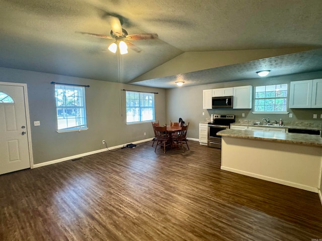 kitchen featuring white cabinets, ceiling fan, appliances with stainless steel finishes, a textured ceiling, and dark hardwood / wood-style floors