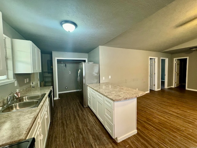 kitchen featuring sink, a textured ceiling, white cabinets, dark wood-type flooring, and stainless steel refrigerator