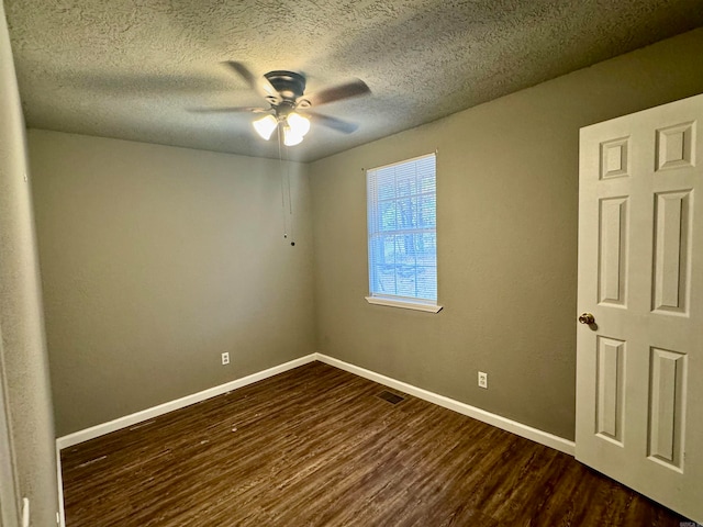 spare room with a textured ceiling, dark wood-type flooring, and ceiling fan