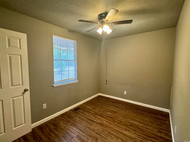 empty room with dark wood-type flooring, a textured ceiling, and ceiling fan