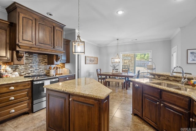 kitchen featuring stainless steel stove, sink, a notable chandelier, decorative light fixtures, and a center island