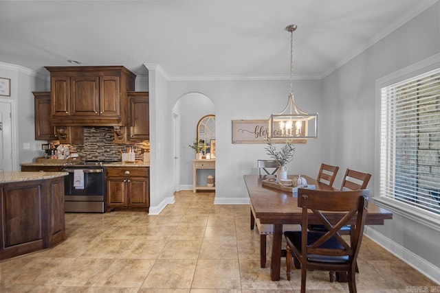 tiled dining space featuring crown molding and a chandelier