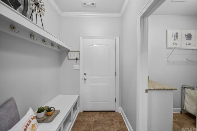 mudroom featuring ornamental molding and dark tile patterned floors