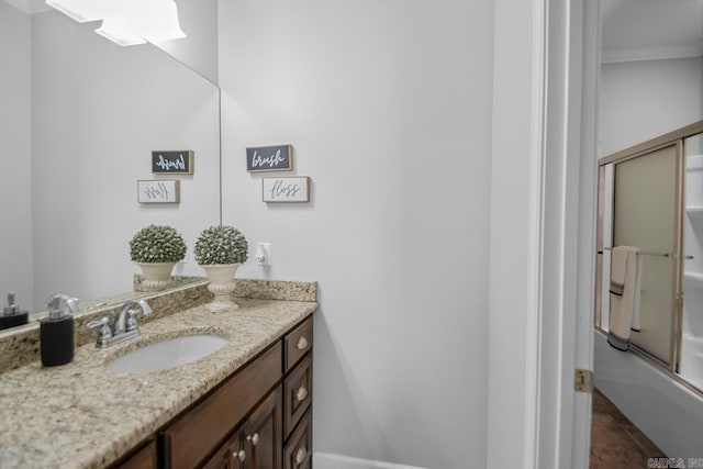 bathroom featuring vanity, crown molding, enclosed tub / shower combo, and tile patterned floors