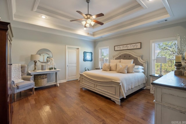 bedroom featuring dark hardwood / wood-style flooring, multiple windows, and a raised ceiling