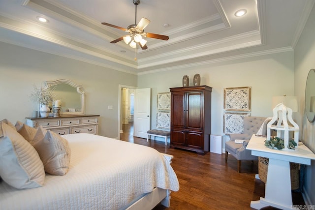 bedroom with crown molding, dark hardwood / wood-style floors, a tray ceiling, and ceiling fan