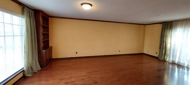 spare room with crown molding and hardwood / wood-style flooring