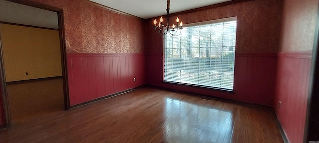 unfurnished dining area featuring hardwood / wood-style flooring and a chandelier