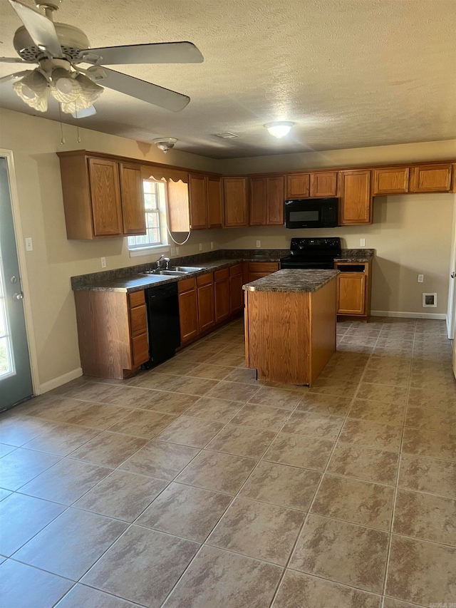 kitchen with ceiling fan, a center island, sink, a textured ceiling, and black appliances