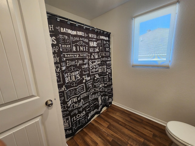 bathroom featuring toilet and wood-type flooring