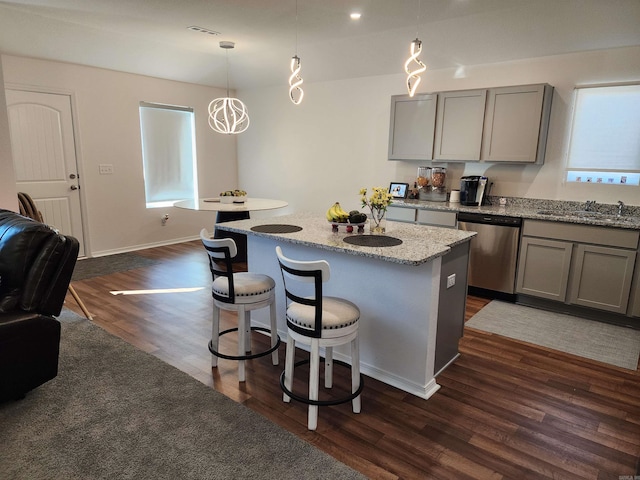 kitchen featuring sink, a center island, hanging light fixtures, stainless steel dishwasher, and dark wood-type flooring