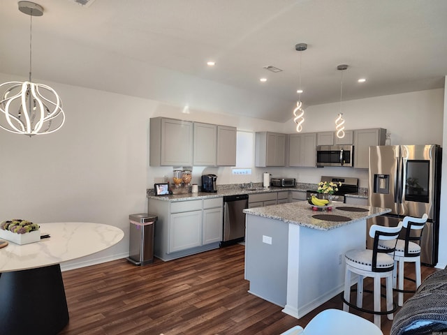 kitchen with a kitchen island, dark hardwood / wood-style floors, hanging light fixtures, stainless steel appliances, and gray cabinets