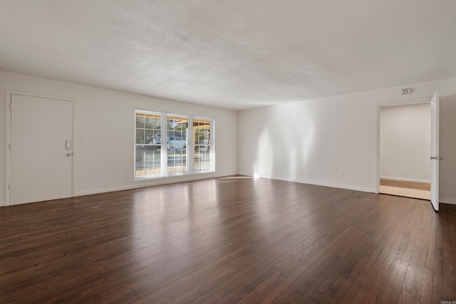 unfurnished room featuring a textured ceiling and dark hardwood / wood-style flooring