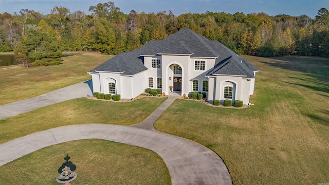 french provincial home with a front yard