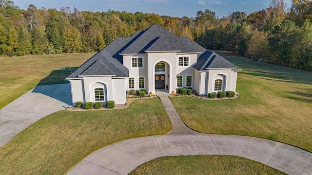 french provincial home with a front yard