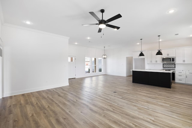 unfurnished living room featuring crown molding, recessed lighting, light wood-style floors, baseboards, and ceiling fan with notable chandelier
