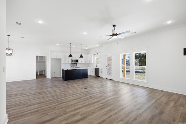 unfurnished living room featuring dark wood finished floors, recessed lighting, visible vents, baseboards, and ceiling fan with notable chandelier