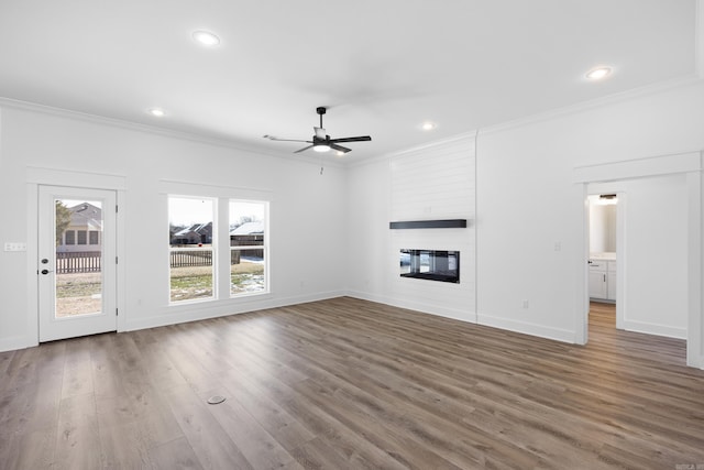 unfurnished living room with recessed lighting, a fireplace, baseboards, dark wood-style floors, and crown molding