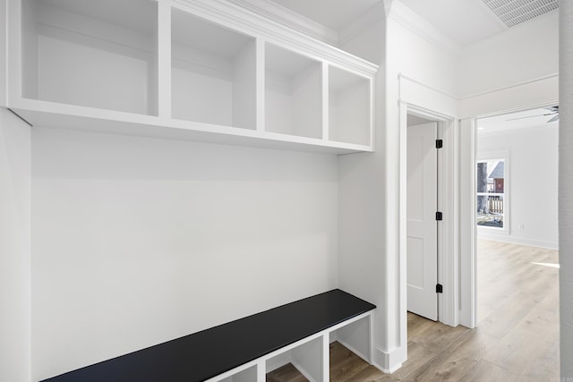 mudroom with ornamental molding, wood finished floors, visible vents, and baseboards
