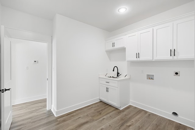 laundry room with cabinet space, light wood-style flooring, washer hookup, and hookup for an electric dryer
