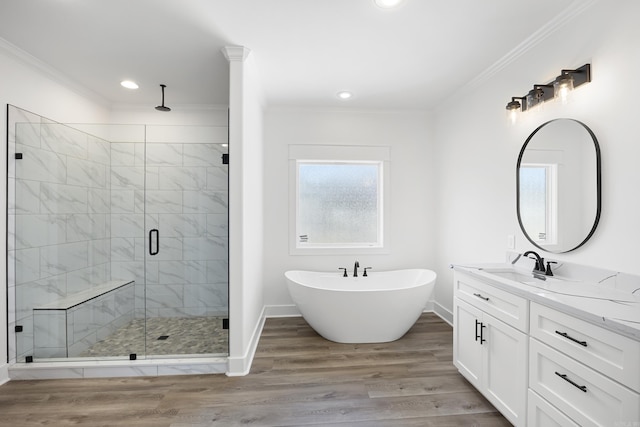 full bathroom with a stall shower, crown molding, a freestanding bath, and wood finished floors
