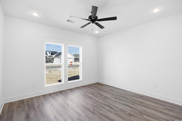 spare room with recessed lighting, visible vents, dark wood finished floors, and baseboards