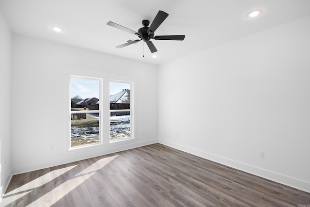 unfurnished room featuring recessed lighting, wood finished floors, and baseboards
