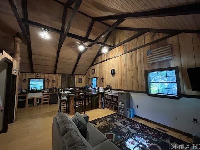 living room featuring beamed ceiling, light hardwood / wood-style flooring, and wooden ceiling