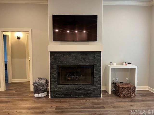 interior space with hardwood / wood-style flooring, crown molding, and a fireplace