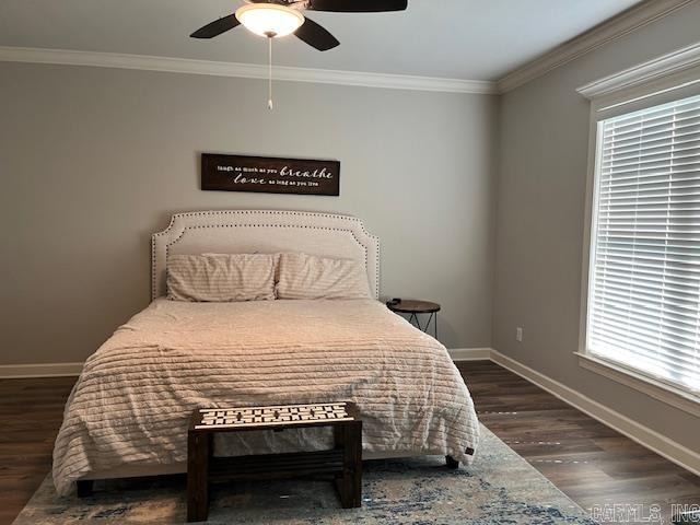 bedroom featuring dark hardwood / wood-style flooring, ornamental molding, and ceiling fan