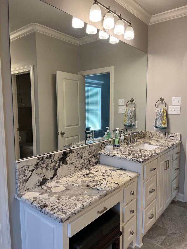 bathroom with toilet, vanity, and crown molding