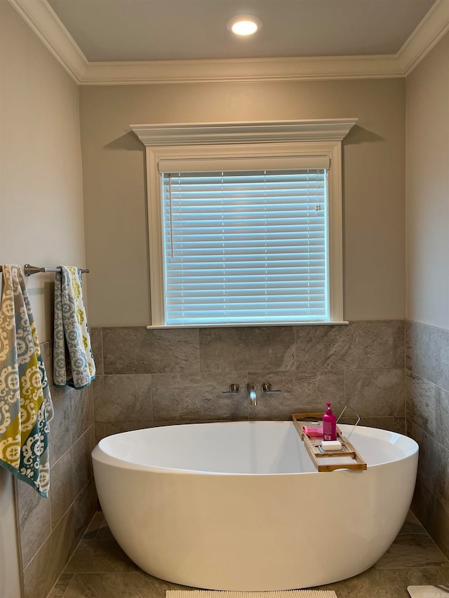 bathroom featuring tile walls, a bath, and ornamental molding