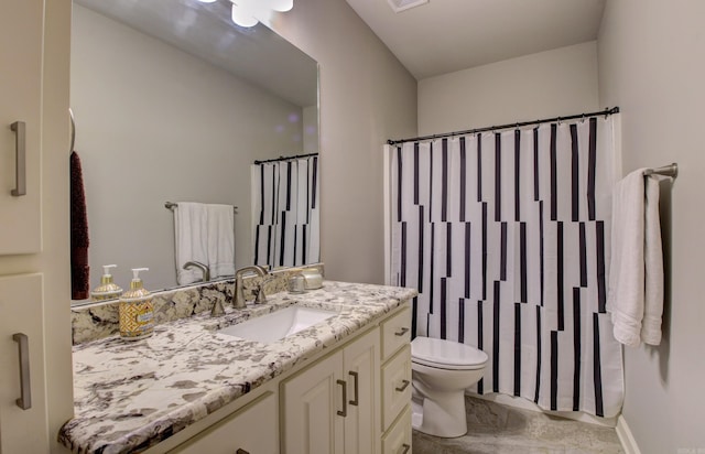 bathroom featuring curtained shower, vanity, and toilet