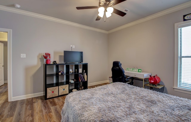 bedroom featuring ornamental molding, hardwood / wood-style floors, and ceiling fan