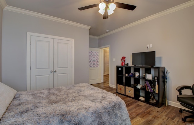 bedroom featuring hardwood / wood-style flooring, ceiling fan, a closet, and crown molding