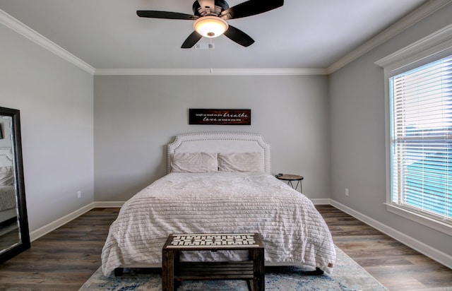 bedroom featuring dark hardwood / wood-style flooring, ceiling fan, and crown molding