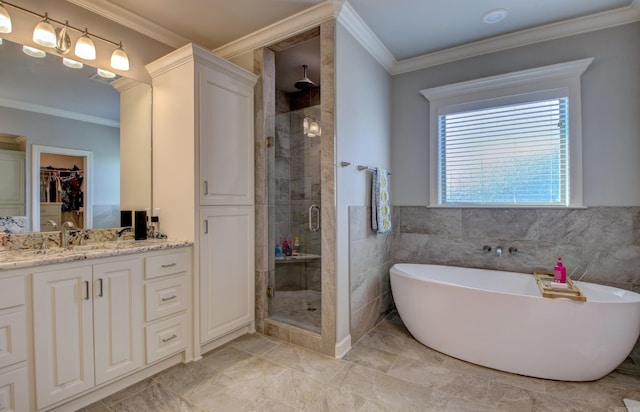 bathroom with tile walls, independent shower and bath, vanity, and crown molding