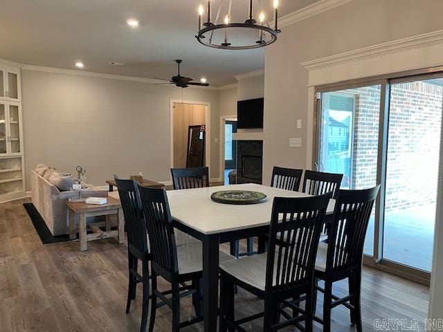 dining room with hardwood / wood-style flooring, ceiling fan with notable chandelier, and crown molding