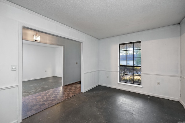 empty room featuring ornamental molding and a textured ceiling