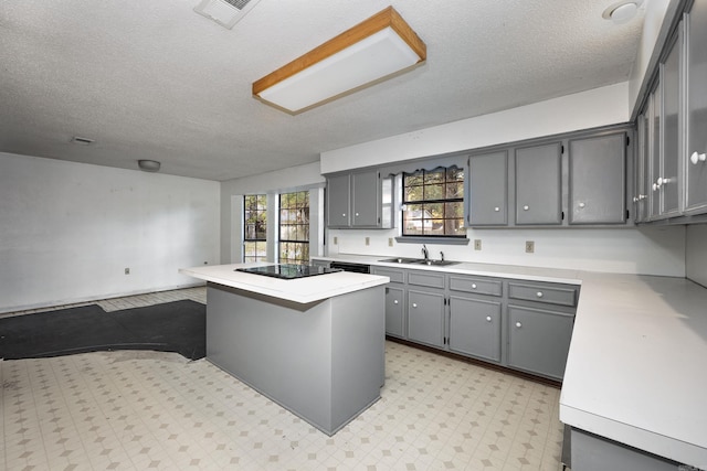 kitchen featuring gray cabinets, black appliances, sink, and a kitchen island