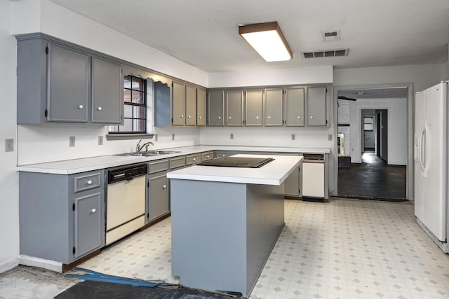 kitchen with white appliances, a center island, and gray cabinetry