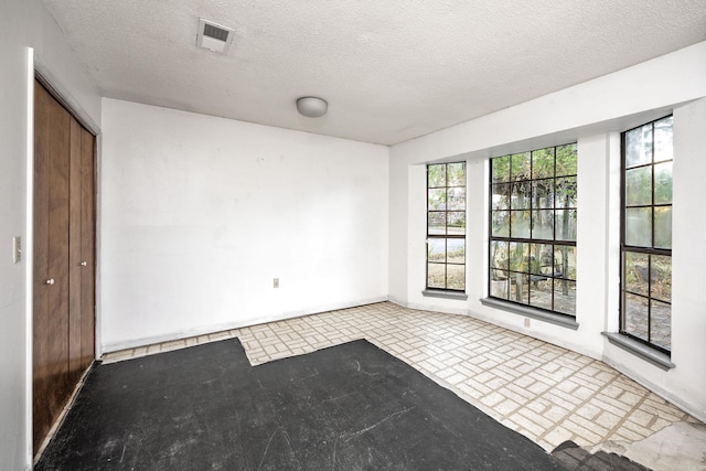 unfurnished room featuring a textured ceiling