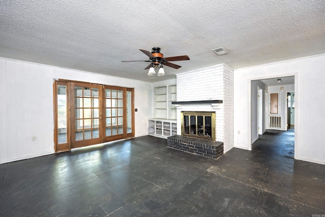 unfurnished living room with built in features, a textured ceiling, and a fireplace