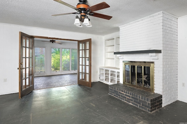 unfurnished living room featuring french doors, a textured ceiling, and a brick fireplace