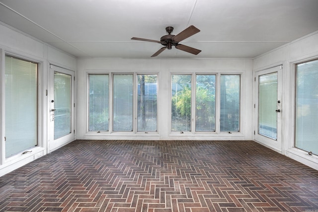 unfurnished sunroom with ceiling fan